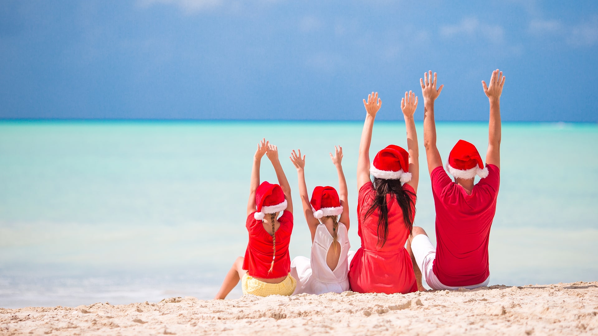 Familie som feirer jul på stranden.