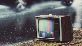 A car passes by an old television with a test pattern displayed.  Composite image.