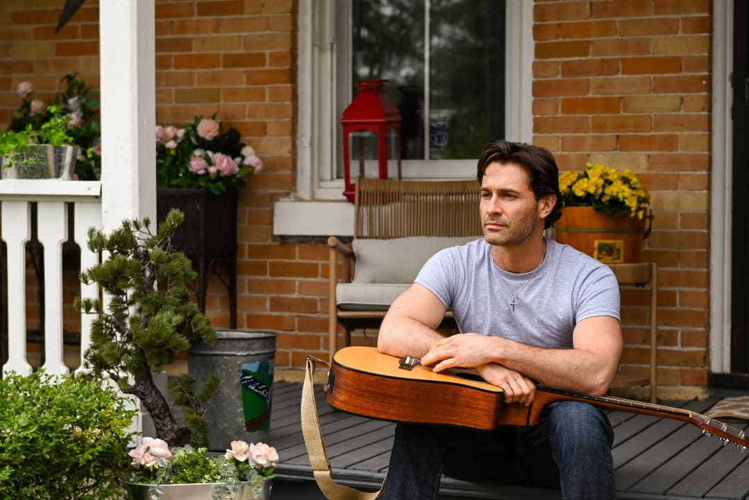 James sits on the porch with his guitar, lost in thought about returning home and his search for faith and direction.